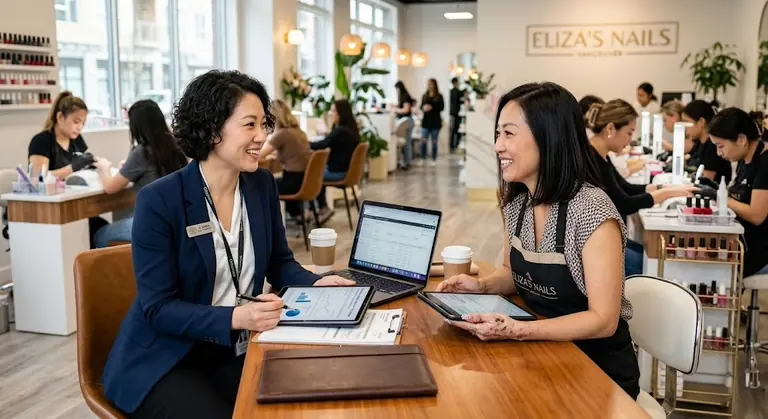 A business advisor reviews salon records with a salon owner while the salon is operating.